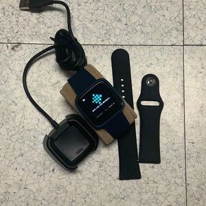 Fitbit Versa fitness tracker with extra silicone band and charger. Working.